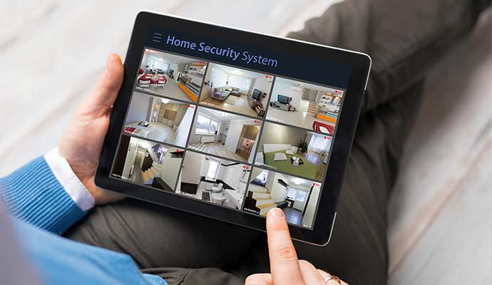 looking at home security cameras on tablet computer